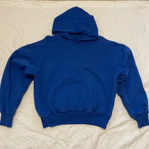 Blå Yeezy Gap Hoodie - Säljer en Yeezy gap hoodie. Hoodien har en väldigt boxy fit och har krympt lite efter några tvättar och därför skulle jag säga att den är mer storlek S. Men den är perfekt för kyliga dagar då den är dubbellagrad med kvalité. Skicket är 9/10 eftersom att den har använts ett fåtalgånger men ändå är som ny om man tänker bort krympningen. Skriv om frågor eller funderingar!