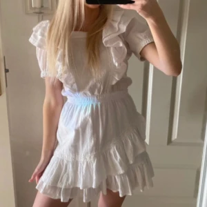 VStudentklänning -  vit  student klänning med volanger och kort ärm. Perfekt för sommarens alla tillfällen. .