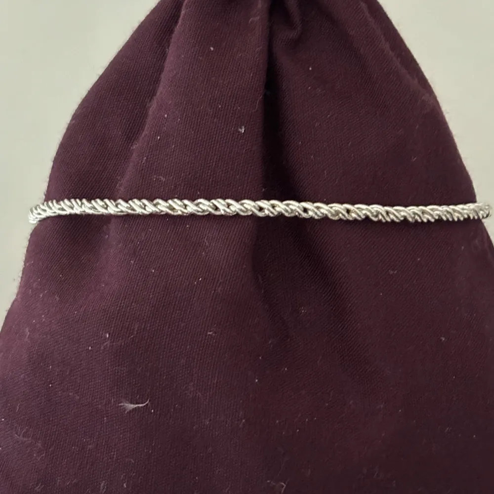 Elegant silverfärgat (ej äkta) armband med en tvinnad design. Armbandet har en justerbar kedja och ett smidigt lås för enkel användning. Skriv vid fler bilder / frågor ❤️. Asusteet.