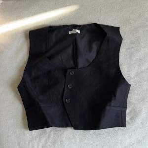 Svart väst-topp från H&M  - Svart väst-topp från H&M. Västen är croppad och lite lös i passformen, aldrig använd men saknar prislapp