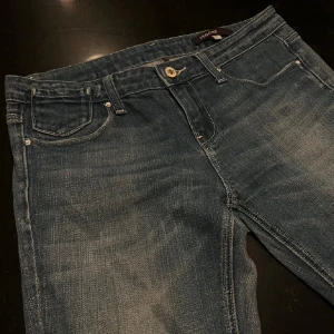 Fina jeans från Vigoss med detaljerade fickor - Snygga blå jeans från Vigoss med broderade detaljer på bakfickorna. Jeansen har normal passform och är lågmidjade och bootcut💕midjemått - 39 cm (rakt över midjan), stussmått - 48 cm (rakt över stussen), innerbenslängd - 71 cm! 💓