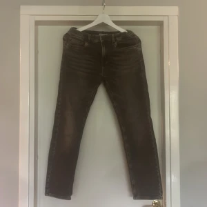 Svarta jeansbyxor från Lindex - Snygga svarta jeansbyxor från Lindex med tvättad look och klassisk femficksmodell. Jeansen har dragkedjegylf, raka ben och normal passform. Stretchig och mjuk passform.