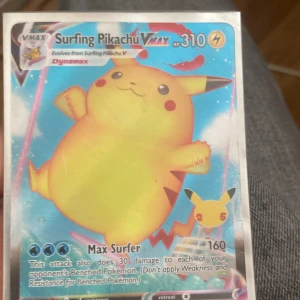 Surfing Pikachu VMAX - Coolt samlarkort med Surfing Pikachu VMAX! Perfekt för dig som älskar Pokémon och vill boosta din samling med en färgstark och unik VMAX-kort. Pikachu surfar fram med maxad energi – ett måste för alla unga Pokémon-fans!
