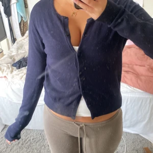 Mörkblå kofta från H&M Basics - En enkel och stilren mörkblå kofta från H&M Basics. Koftan har långa ärmar, rund halsringning och knäppning framtill med små knappar. Supermjuk och bekväm. 