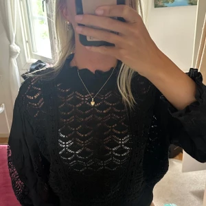Svart stickad blus med volangkrage - Supersnygg svart stickad blus med genombrutet mönster och volangdetaljer, lite croppad modell från Zara i storlek L men passar som storlek S eller xs