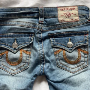 True Religion Joey Low Rise Flare Jeans - Lågmidjade true religion jeans! Storlek 25, jag är 172 och dom är bra i längden för mig! Väldigt bra skick förutom lite slitna längst ner på jeansen men inget som syns (sista bilden) nypris 1600, mått rakt över midjan: 36cm. 