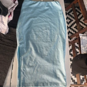 Ljusblå ribbad långkjol från SHEIN - Ljusblå långkjol från SHEIN i ribbat material. Kjolen har en tight passform och elastisk midja för extra komfort. Perfekt för dig som gillar en enkel men snygg look. Storlek XS.