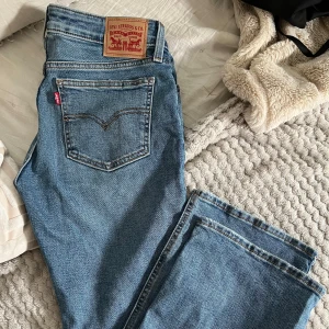 Levi's Superlow Bootcut jeans blå - Säljer ett par klassiska Levi's Superlow Boot jeans i blå denim. Modellen har låg midja och lite bootcut-ben, med snygga detaljer. Perfekta för dig som gillar en avslappnad och stilren look.