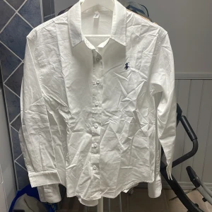 Vit skjorta från Ralph Lauren - Klassisk vit snygg skjorta från Ralph luren. Säljer för den blivit för liten och ligger mest och skräpet i min garderob. Jag skulle säga att den passar till dig som är runt 170-180 cm. Nypris 1000, skriv ifall du har frågor. Pris kan äve diskuteras! 