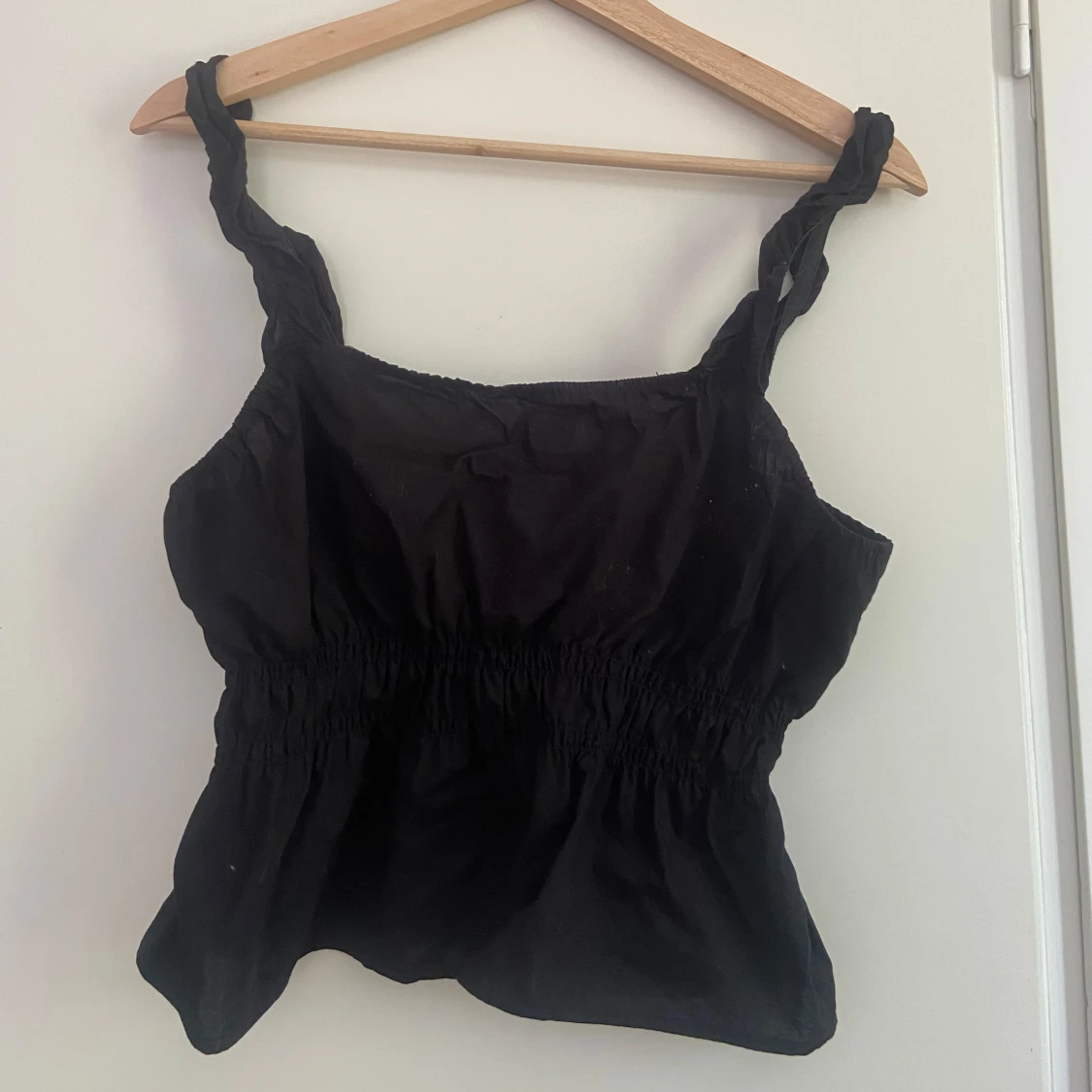 Svart linnetopp med twistade axelband