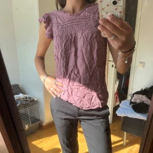 Ljuslila blus från Esprit XS - Supersöt ljuslila/rosa blus från Esprit. Blusen har volangärmar, rynkade detaljer upptill och en avslappnad passform. 