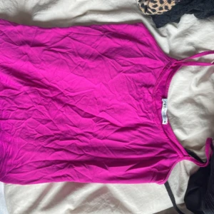 Rosa linne från Zara - Säljer en snygg och enkel rosa linne från Zara. Toppen har tunna axelband och är tillverkad i ett mjukt material som känns skönt mot huden. Perfekt att matcha med jeans eller kjol för en fräsch look.