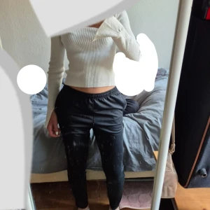 Svarta Nike träningsbyxor - Svarta träningsbyxor från Nike med smal passform och elastisk midja. Byxorna har dragkedja vid fickorna och en diskret Nike-logga på sidan. Perfekta för chill eller träning, riktigt sköna och stilrena.