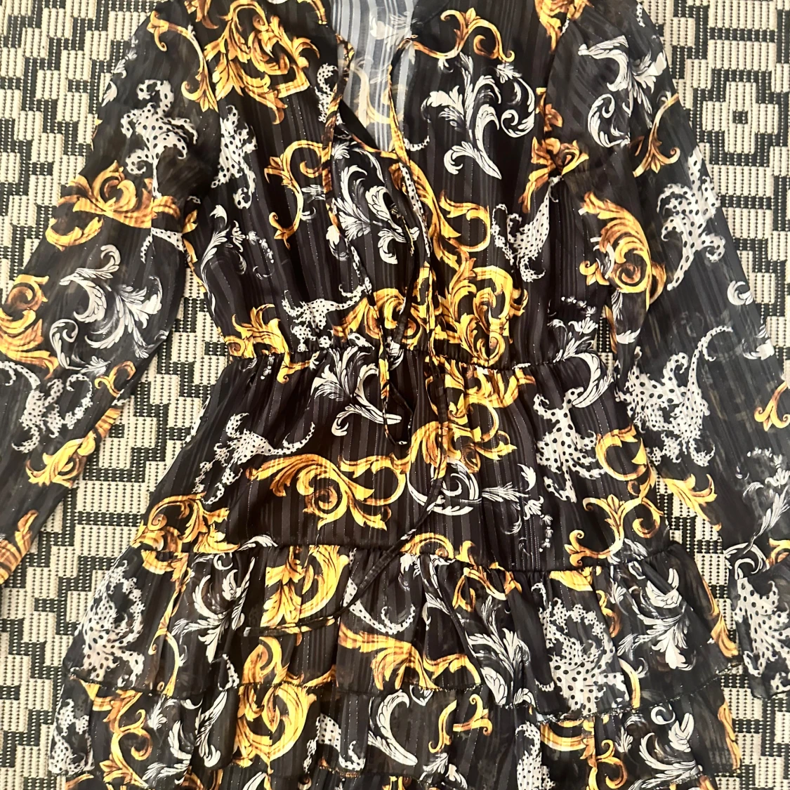 Svart och guldig mönstrad kortklänning