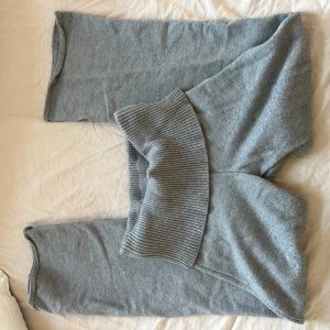 Grå mjukisbyxor från Gina Tricot - Supermysiga grå mjukisbyxor från Gina Tricot med bred ribbad midja och raka ben. Perfekta för chill dagar hemma eller när du vill vara extra bekväm. Tillverkade i mjukt material som känns skönt mot huden.