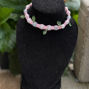 Armband sommar blad rosa blå - Handgjort armband “Blomsterdröm”  Letar du efter det där lilla extra till din outfit? Upptäck detta unika, handgjorda armband , en romantisk blomsterdröm i rosa toner.   ✨ Knuten i rosa tråd med skimrande pärlor i blått och rosa ✨ Söta gröna blad som ger ett naturligt, sagolikt uttryck ✨ Justerbart knäppe bak, passar de flesta handleder ✨ Perfekt till både vardag och fest  Varje armband är unikt och skapat med kärlek och känsla för detaljer.
