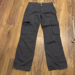 Gråa cargopants från Gina Tricot perfect jeans - Snygga grå cargopants från g perfect jeans med raka ben och stora fickor på sidorna. Byxorna har normal passform och är tillverkade i bomull, perfekta för en avslappnad streetstil. Använda 2 gånger, bra skick! Köpa för ca 400kr säljer för 100kr. Hör av er vid frågor!