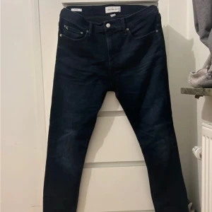  Jeans Calvin Klein  - W34 L32.   Snygga mörkblå jeans från Calvin Klein Jeans i klassisk femficksmodell. Jeansen har raka ben och normal passform, med diskreta sömmar och metallknapp med CK-logga. Perfekta för dig som gillar stilrena och tidlösa jeans.