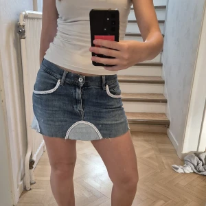 Jeanskjol med spetsdetaljer - Super söt omsydd jeanskjol från TIGER, som tidigare vart jeans! Spets detaljer på bland annat fickorna! Stl 30/34 men större nu när det är en kjol. 
