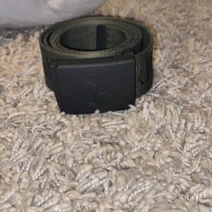 Mörkgrönt bälte med svart spänne - Säljer nu mitt snygga peak performance skärp då jag har har användt det på ett tag och säljer det därmed till ett shcysst pris! Kontakta mig vid mista fråga eller fundering