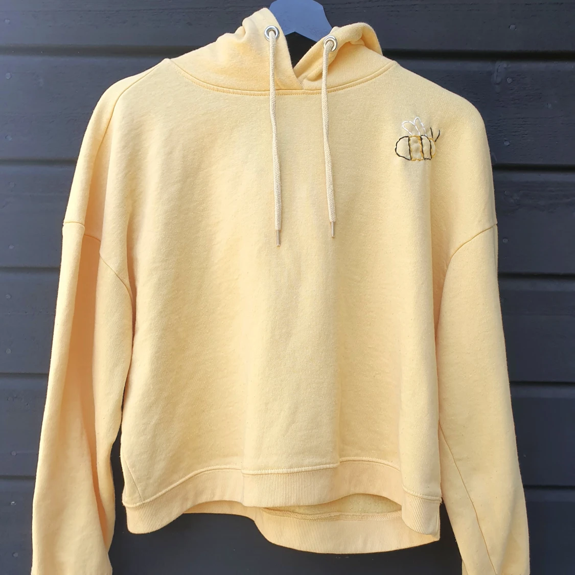 Ljusgul hoodie med handbroderad humla