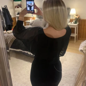 Svart offshoulder blus med ballongärm - Säljer en svart blus med vida, transparenta ballongärmar. Går att ha både offshoulder samt ”vanligt”. Baktill har en del av dragkedjan försvunnit men går att använda ändå. Passar XS-S