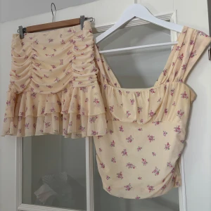 Blommigt set - Supergulligt gult sett med rosa blommor. Använt ett fåtal gånger så fin kvalitet. Det är lite gulare i verkligheten än vad som syns på bilderna.