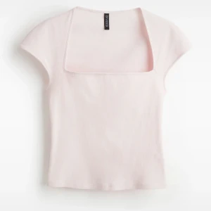 Ljusrosa ribbad topp från hm - Supersöt ljusrosa topp från hm med ribbad struktur och fyrkantig urringning. Modellen är kortärmad och har en tight passform som framhäver siluetten. Perfekt att styla med jeans eller kjol för en trendig look.