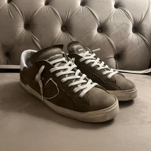 Philippe Model sneakers - Snygga sneakers från Philippe Model i olivgrön mocka med vita snören i storlek 41 men passar 41/2. Ny pris 3500kr. Box ingår, pris kan diskuteras 