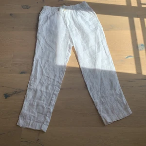 Vita linnebyxor - Säljer ett par vita linnebyxor från Jack & Jones med elastisk midja. Byxorna har både fram och bak fickor. Perfekta för varma dagar och ger en chill vibe till din outfit.