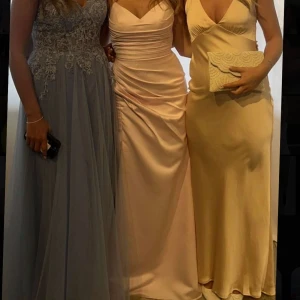 Balklänning rosa - Supersnygg ljusrosa balklänning. Klänningen har smala axelband, markerad midja och en slits framtill. Materialet är glansigt och känns lyxigt, perfekt för bal. Endast använd 1 gång. Den är från hemsidan jjs house. Skriv vid frågor