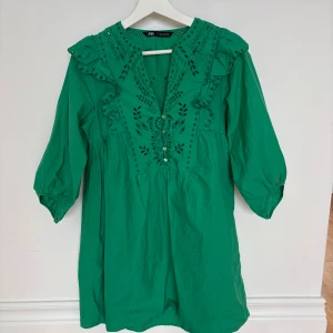 Grön broderad kortklänning från Zara - Supersöt grön kortklänning från Zara med broderade detaljer och volanger vid axlarna.
