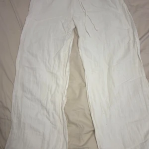 Vita linnebyxor från Nelly, strl 32 - Säljer ett par vita linnebyxor från Nelly i storlek 32. Byxorna har rak och loose passform, elastisk midja med snörning och är tillverkade i mjukt linne. Perfekta för chill dagar och sommarhäng. Snyggt och enkelt att matcha med crop tops eller hoodies. Tyvärr lite sönder ner vid byxan därför ett billigt pris. Men funkar utmärkt ändå eftersom man inte ser det när man har på sig byxorna.