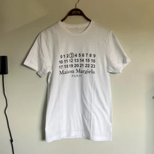 Maison margiela t shirt - Riktigt fet och eftertraktad Maison margiela t shirt i storlek S! Helt nytt skick! Lite osäker på äktheten så därför är priset just nu på 398kr nypris runt 3000kr! Tveka inte med att ställa frågor! 