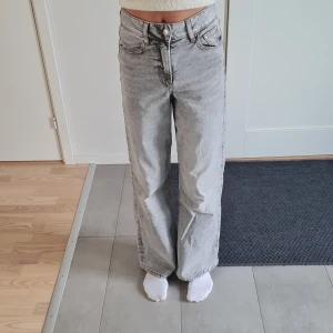 Grå wide jeans från Perfect Jeans - Snygga grå jeans från Perfect Jeans i storlek 34. Modellen har hög midja och breda ben. Klassisk femficksdesign med silverfärgade knappar och dragkedja. Jeansen är tillverkade i mjukt denim-material. Har bara använts 1 gång, så är som nya! Jag är 170, så om man är lite kortare kommer dem här jeansen vara väldigt långa.