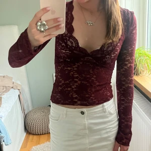 Vinröd spetsblus med v-ringning - Säljer en vinröd, långärmad blus i spets med v-ringad hals. Köpt ifrån GinaTricot och endast använd en gång!🥰