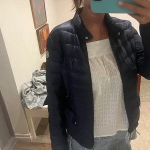 Mörkblå dunjacka från Moncler - Snygg mörkblå dunjacka från Moncler. Den är köpt på Vestiaire och har gått förbi äkthets kontroll som man ser på sista bilden.