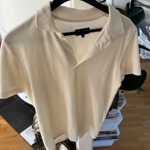 Beige pikétröja från Nikben  - Säljer en stilren beige pikétröja från Nikben med klassisk krage och knappslå. Tröjan är kortärmad och gjord i mjuk bomull som känns skön mot huden. Perfekt för dig som gillar minimalistisk och clean stil. Pris går alltid att diskutera!