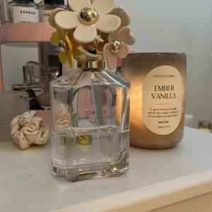Daisy Eau So Fresh parfym Marc Jacobs - Daisy Eau So Fresh från Marc Jacobs är en ikonisk parfym i en genomskinlig glasflaska med ett unikt blommigt lock i vitt, beige och gult med gulddetaljer. Flaskan är stilren och feminin, perfekt som en snygg detalj på sminkbordet.