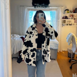 Svartvit pälsjacka från Karen Kare - svartvit pälsjacka från Karen Kane med coolt ko-mönster. Jackan har två fickor framtill och stängs med knappar. Det är storlek L men passar typ S med oversized stil. Aldrig använd.