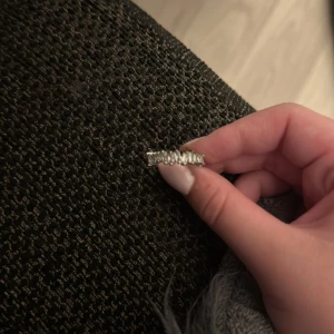 Silverring med glittriga stenar - Snygg silverfärgad ring med glittrande stenar runt hela bandet. Ringen har en modern design med stenar som ger extra bling och lyser upp handen. Perfekt för dig som vill ha något som sticker ut och ger en lyxig känsla.