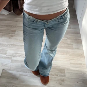 Ljusblå bootcut jeans låg midja - Säljer ett par ljusblå jeans med bootcut och låg midja från Nelly. Jeansen har fransad kant upptill med snyggt slitna detaljer och riktigt skön passform 💞 nypris 699