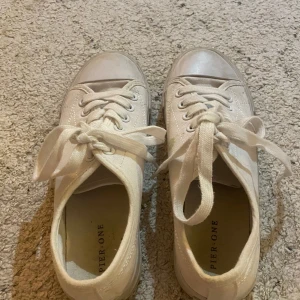 Vita sneakers  - Snygga vita sneakers från Pier One med klassisk låg design och rund tå. Skorna har snörning och är tillverkade i bomullstyg med platt sula. Perfekta för dig som gillar enkel och clean stil. Passar till jeans, shorts eller kjol för en chill look.