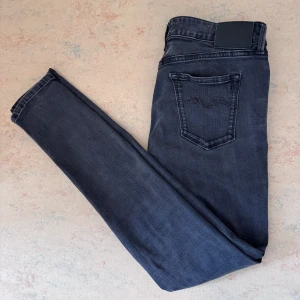 Replay ambass mörkgrå - Snygga Replay ambass jeans i mörkgrå tvätt med slim passform. Klassisk femficksmodell, låg midja och stretchigt jeanstyg som sitter tajt hela vägen ner. Diskret Replay-logga vid fickan och svarta detaljer. Perfekta för dig som gillar en smal siluett. Mitt pris 549, nypris 1100kr