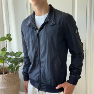 Jacka J.lindberg / vindjacka   - Minimal defekt på zipen men märks inte, den är lite skrapad ungefär påverkar inte själva zip funktionen. Modellen bär M och ör 180,75 kg. Perfekt nu till hösten, kom med frågor! Psst har en exakt likadan fast i svart 🙏