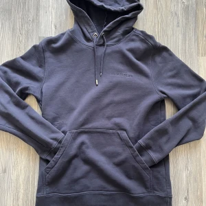 Blå hoodie från J.Lindeberg - Säljer nu denna mörkblåa hoodie från J.Lindeberg för 349. Vid snabb affär kan jag sänka lite annars fast pris. Storlek S men sitter som en XS, lite stor för mig som är 170. Skriv gärna vid frågor🙌 (har även tappat en av topparna på snöret)