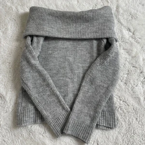 Stickad off-sholder tröja💗 - Säljer en grå stickad off-shoulder tröja från MNG med bred, nedvikt krage och ribbad struktur!💗 Tröjan har långa ärmar och är mjuk och skön, perfekt för höstdagar/vårdagar eller på en sommarkväll.🍂🌸☀️Enkel att matcha med olika outfits.