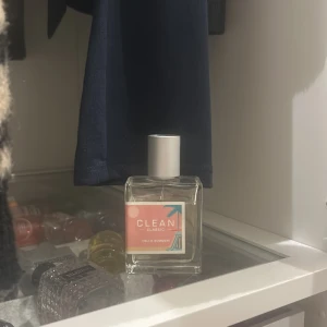 Clean Classic Hello Flower Eau de Parfum - En fräsch parfym från Clean Classic med namnet Hello Flower. Flaskan är rektangulär i genomskinligt glas med en vit kork och en etikett i rosa och turkos. Perfekt för dig som gillar blommiga och lätta dofter.