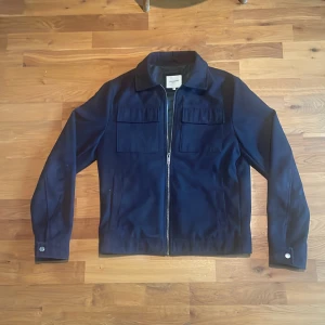 Overshirt Jack & Jones - Säljer en svart/mörkblå Overshirt från Jack & Jones med dragkedja. Den är sparsamt använd och inte alls mycket använd inga slitage. Nypris 1200kr. Kille på bilden är 174 cm och 57kg. Hör av dig vid mer frågor!