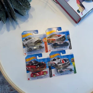 Hot Wheels samlarbilar - 4-pack - Fyra Hot Wheels bilar i originalförpackning: LB-Silhouette Works GT Nissan 35GT-RR Ver.2 (silver), BMW M3 Wagon (röd), Custom '68 Camaro (vit/röd) och Dodge Viper SRT10 ACR (vit/blå/röd). Perfekt för samlare eller bilentusiaster. 